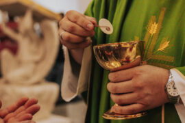 Padre distribuindo a sagrada comunhão na missa