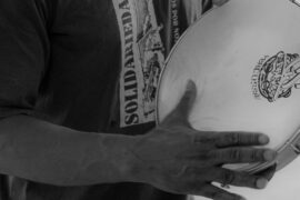 Homem tocando samba através de um pandeiro