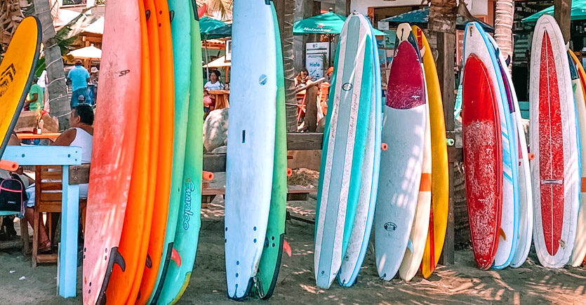 Modelos de prancha de surf enfileirados na praia